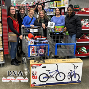 DNA team posing with shopping carts full of christmas gifts